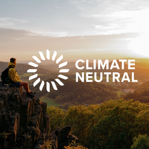 Man sitting on edge of a cliff with Climate Neutral Logo